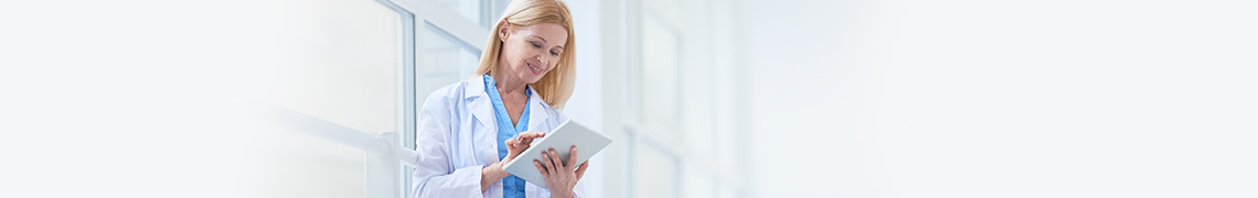 Woman in medical clothing reviews RALS link on a tablet device.